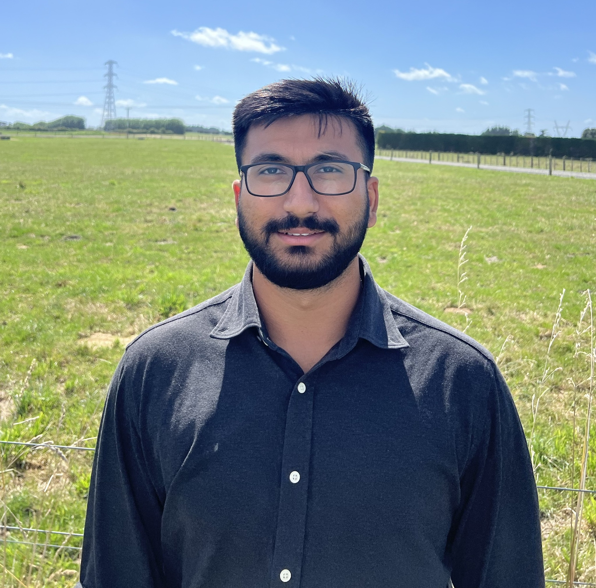 Man with dark hair, beard and glasses
