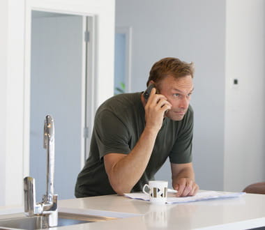 man in kitchen on phone