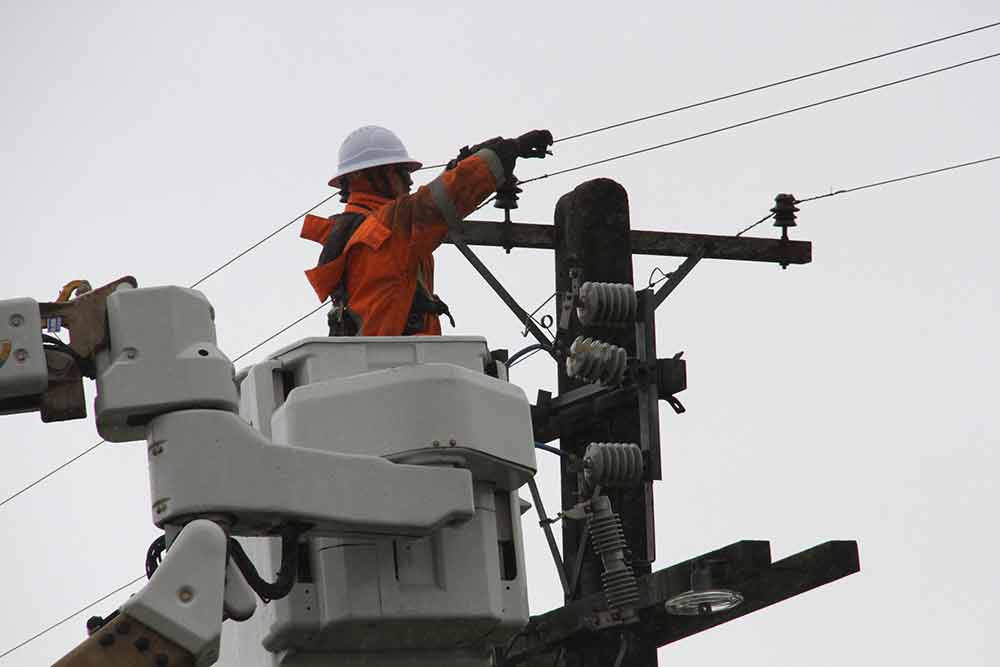 Crew working on overhead line from a cherry picker.