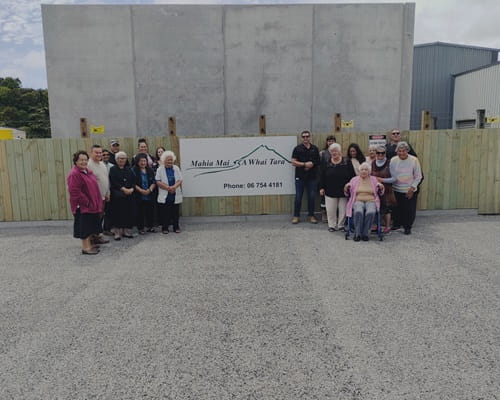 A group of elderly people in front of a concrete wall